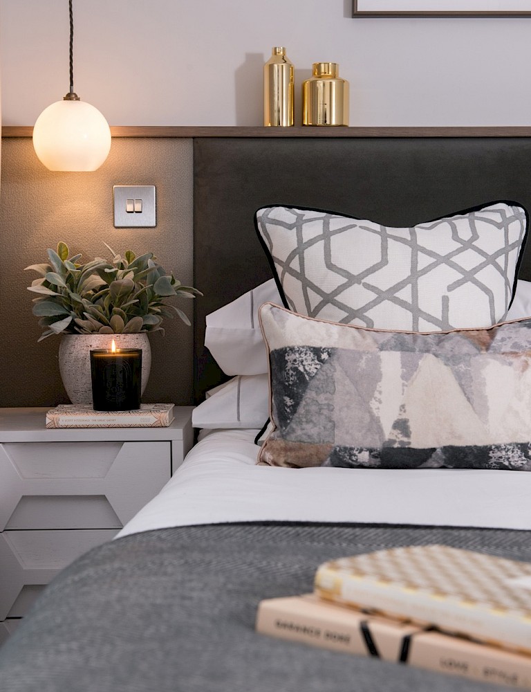 Knightsbridge townhouse master bedroom — layered cushions, geometric textiles, brass accessories and globe pendant light by Hestia & Hearth London
